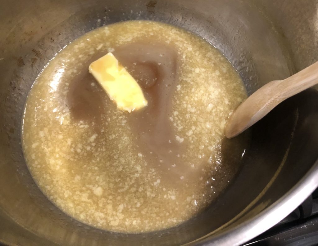 butter melting in a large stainless steel pot combined with pure maple syrup