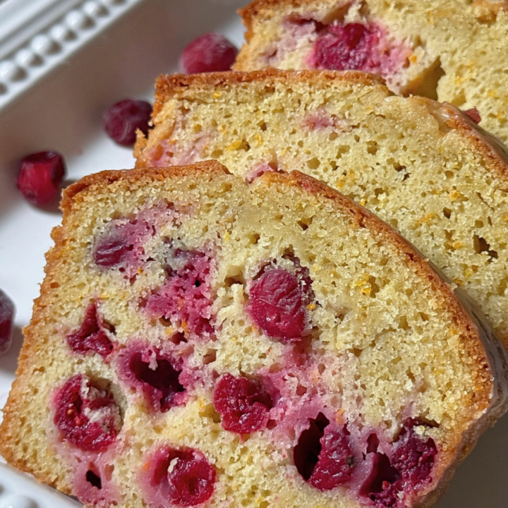 Slices of cranberry orange bread showing whole cranberries throughout the loaf