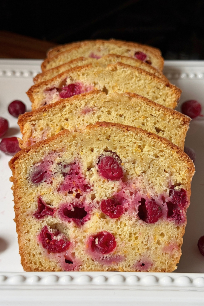 Sliced cranberry orange bread with whole cranberries and fresh orange zest