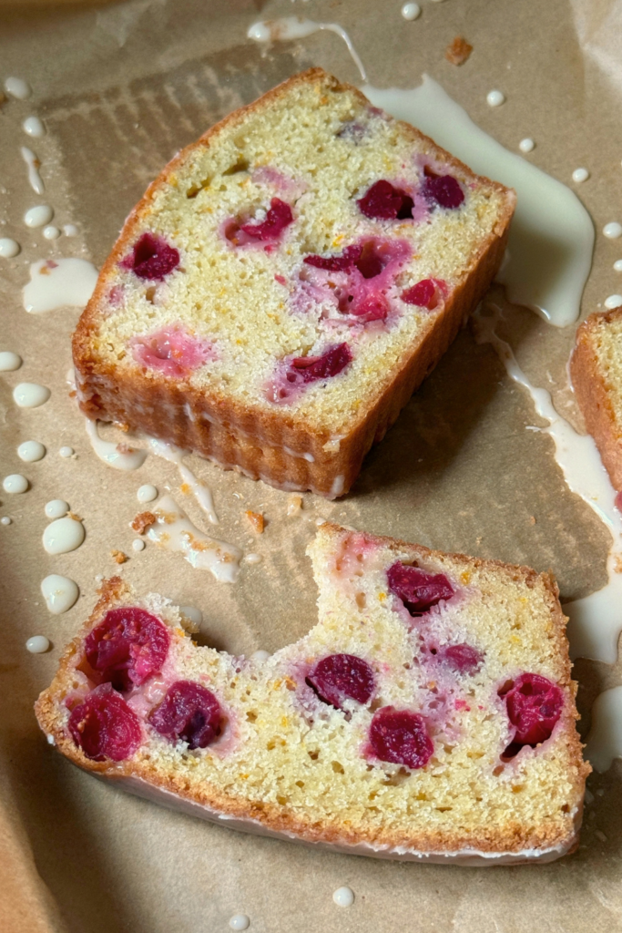 Slices of cranberry orange bread showing whole cranberries throughout the loaf